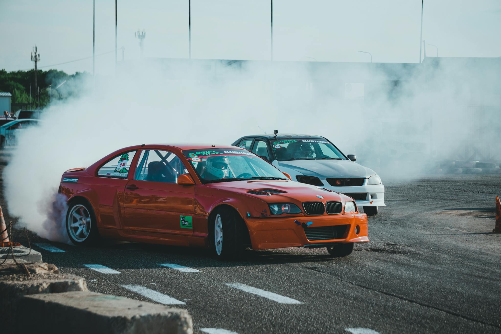 Dynamic scene of car drifting on track creating smoke clouds during an adrenaline-fueled competition.
